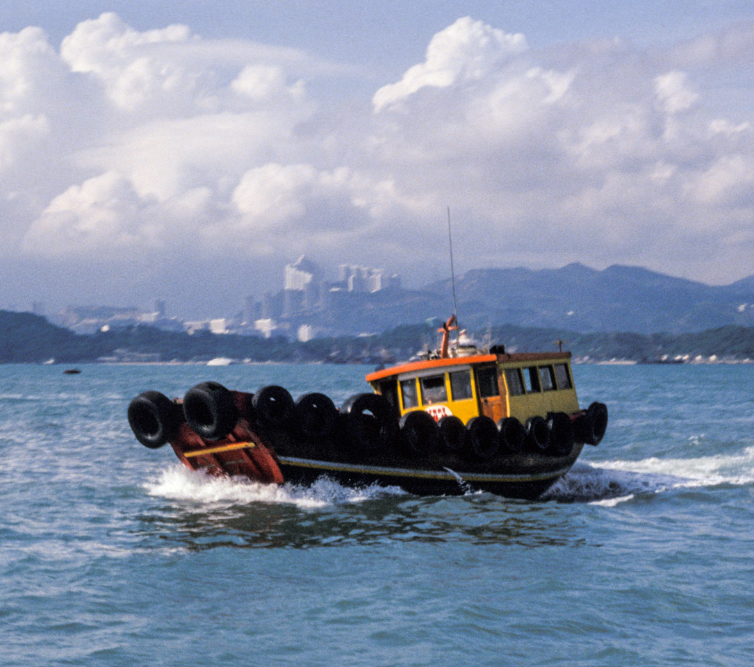 Red and yellow motor boat with its sides lined with old tires